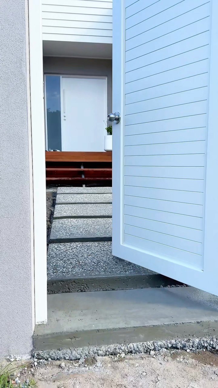 Gate opening onto floating aggregate pavers and the front door